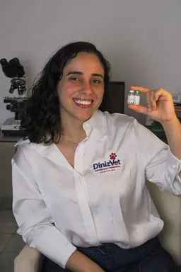 Veterinária da DinizVet apresentando frascos de vacina