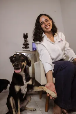 Veterinária da DinizVet ao lado de um cão